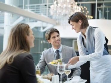 Waitress serving food to couple in restaurant Waitress serving food to couple in restaurant